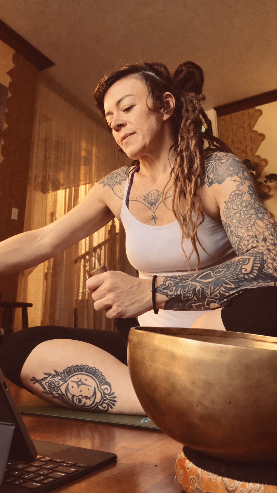 Kelli in her home chanting practice beside a singing bowl